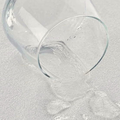 Wasser aus einem umgekippten Glas perlt auf der Oberfläche ab